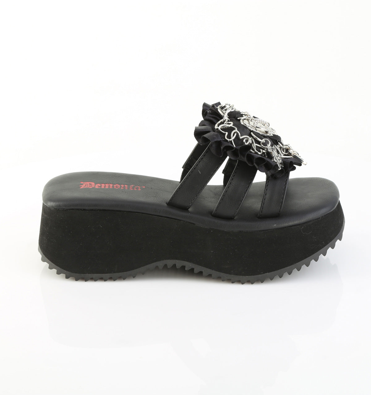 Side view of black Demonia flip-16 platform sandal with thick wedge sole, triple black straps, ruffled trim, and silver gothic heart and cross charms.