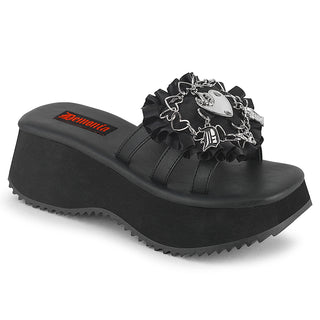 Demonia Flip-16 platform slide sandal with a thick wedge sole, ruffled black strap, and silver heart and cross gothic charm detailing.