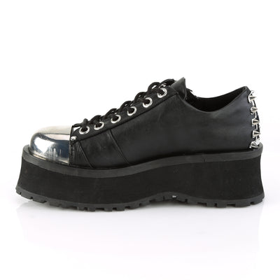 Inner side view of Demonia Gravedigger-04 black platform Oxford with chrome toe cap, lace-up front, and spiked heel detailing on a white background.