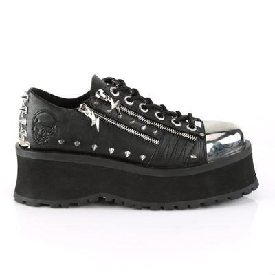 Outer side view of Demonia Gravedigger-04 black platform Oxford with chrome toe cap, double zippers, pyramid studs, and embossed skull detail on heel.