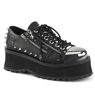 Demonia Gravedigger-04 unisex black platform Oxford shoe with silver chrome toe cap, metal zippers, pyramid studs, and embossed skull heel.