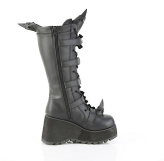 Outer side view of Demonia SCENE-157 black knee-high platform boots with bat-shaped buckles, inner zipper, and rubber horn details