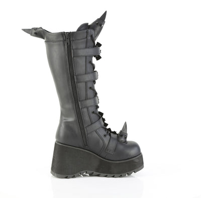 Outer side view of Demonia SCENE-157 black knee-high platform boots with bat-shaped buckles, inner zipper, and rubber horn details