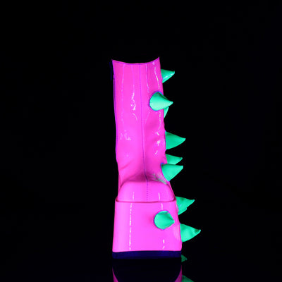 Front view of the Demonia Slay-77 neon pink platform boot with soft green UV-reactive spikes running up the center, photographed under blacklight.