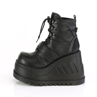 Demonia Stomp-13 black wedge platform ankle boot with lace-up front, hook-and-loop strap, and quilted panels, side view on white background.