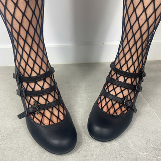 Front view of Demonia Vivika-38 black multi-strap Mary Jane shoes with fishnet tights