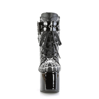 Front view of Demonia Torment-51 platform boots showing black laces, coffin buckle strap, and white spiderweb print on matte upper.