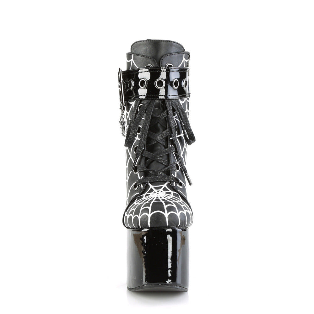 Front view of Demonia Torment-51 platform boots showing black laces, coffin buckle strap, and white spiderweb print on matte upper.