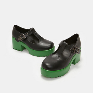 Black Mary Jane platform shoes with chunky green soles and a T-strap buckle design.