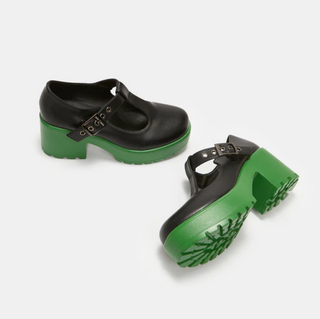 Black Mary Jane platform shoes with bright green soles, T-strap buckle design, and treaded bottoms.